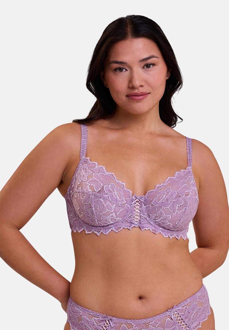 Reggiseno in pizzo lavanda con motivo floreale, bordi smerlati e dettagli incrociati al centro. Spalline regolabili. Slip in pizzo coordinato.