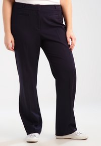 Pantalon bleu marine en tissu lisse, doté d'une coupe droite, de poches avant et de plis subtils pour un look soigné.