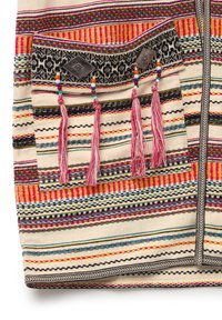 Multicolored textile featuring a pattern of stripes with pink, blue, and black. Includes a decorative pocket with tassels and bead accents.
