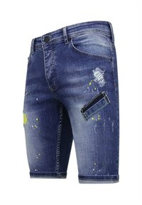 Donkerblauwe denim shorts met distressed delen, verfsplashers en een patch pocket met een groene accent. Middellange snit.