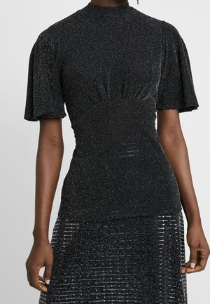 Black fitted dress with short puff sleeves and subtle silver sparkles, worn by a standing person against a plain background.