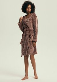 Brązowy, kapturowy szlafrok wykonany z pluszowej tkaniny o fakturze w jodełkę, z paskiem w talii i dwoma przednimi kieszeniami.
