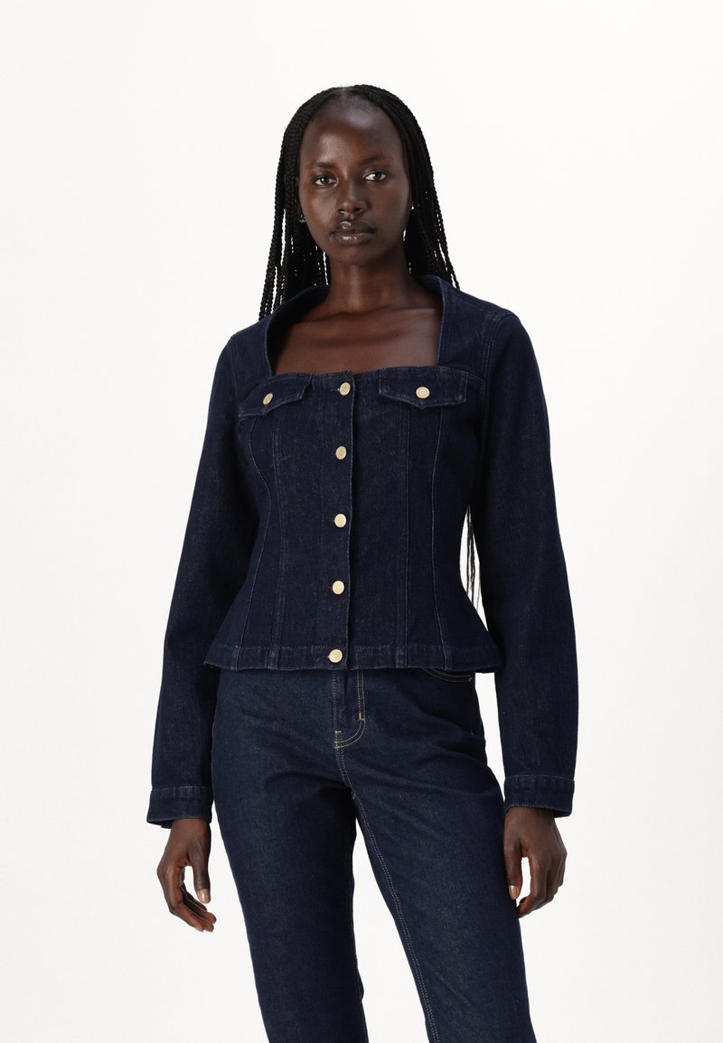 Giacca in denim scuro con maniche lunghe, scollatura quadrata e bottoni dorati. Presenta tasche sul petto e una silhouette aderente.