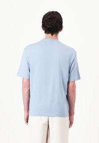Light blue short-sleeve t-shirt, round neckline, soft cotton material, relaxed fit, smooth texture, minimalistic design, no visible patterns.