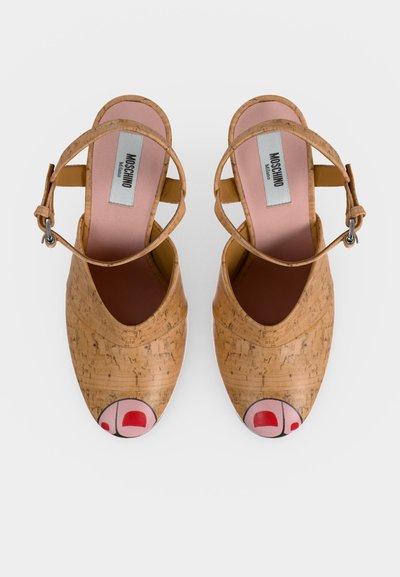 Καφέ παπούτσια Mary Jane με υφή φελλού, ιμάντες στον αστράγαλο και σχεδιασμένα κόκκινα σχέδια στα δάχτυλα των ποδιών στις στρογγυλεμένες μύτες, εσωτερικά με την επιγραφή Moschino Milano.