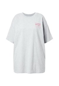 Camiseta gris de gran tamaño en tejido suave, con mangas cortas y cuello redondo, que presenta un pequeño estampado gráfico rosa en el pecho.