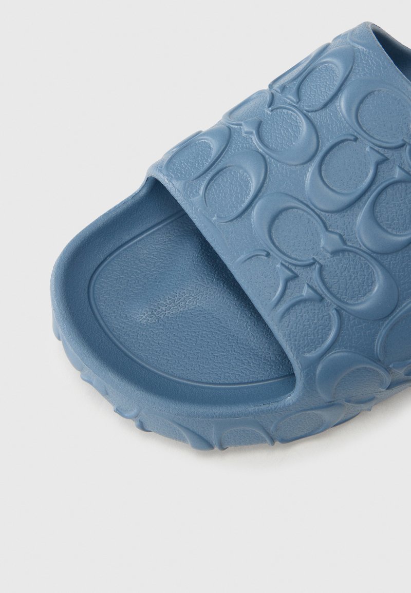 Blaue Gummipanale zum Hineinschlüpfen mit strukturierter Oberseite und Muster aus ineinandergreifenden Kreisen; geformtes Fußbett für Komfort.