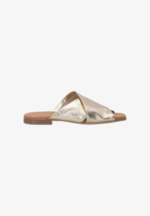 Metallische gouden slide-sandaal met een crisscross-ontwerp, open teen, platte zool en lichtbruine binnenzool. Glad textuur, minimale hardware.