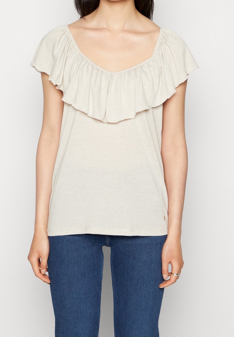 Lys beige t-shirt med dyb V-hals og en bred volangkrave. Fremstillet af blødt stof, har korte ærmer og en afslappet pasform.