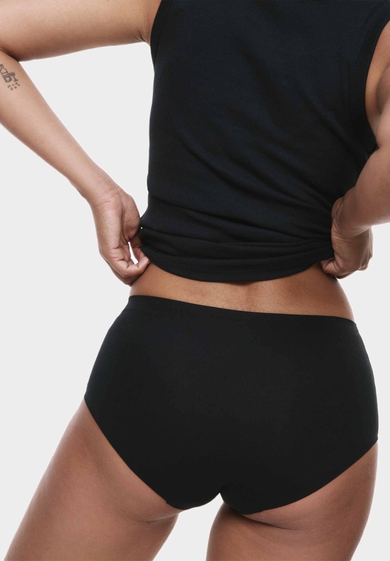 Schwarze Hochbund-Unterhose aus weichem, dehnbarem Stoff. Verfügt über glatte Kanten und ein Design mit vollwertiger Abdeckung. Sichtbares geripptes schwarzes Tanktop.