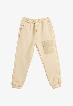 Beige sweatpants lavet af blødt materiale, med elastisk talje, sidelommer og en enkelt stiklomme på højre ben.