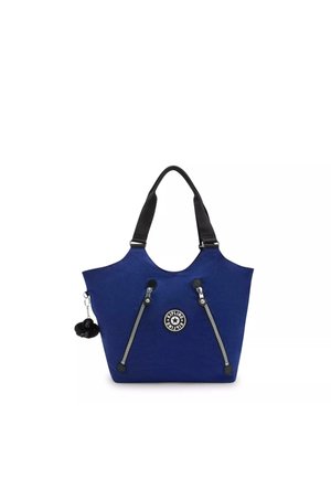 Blue fabric tote bag with black straps, featuring a round logo, two side zippers, and a black pom-pom accessory attached.
