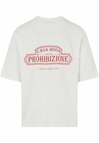 Camiseta blanca de manga corta con cuello redondo. Presenta una impresión gráfica roja en la parte trasera, que muestra "CASA MODA 10119 PROHIBIZIONE."