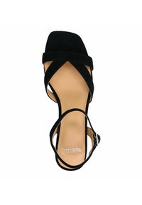 Zwarte suede sandaal met hak, gekruiste banden, vierkante neus, beige binnenzool en een zilveren gesp op de verstelbare enkelband.
