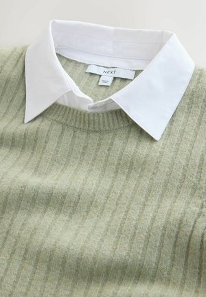 Hele-roheline kampsun vertikaalsete ribidega, ümmarguse kaelusega, all valge kraega särk. Kaeluse juures on hooldustähis nähtav.