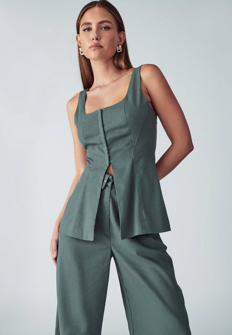 Groen linnenmix top met een vierkante halslijn, knoopsluiting aan de voorkant en paneeldetails, gecombineerd met wijduitlopende bijpassende broek.