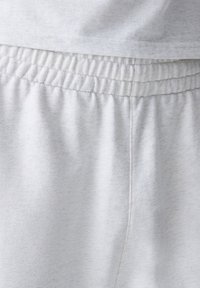 Pantalones de chándal de mezcla de algodón gris con cintura elástica, que presentan una textura suave y acentos acanalados cerca de la cintura para mayor comodidad.