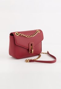 Rød syntetisk læder handbag med en guld kædetræk, en klaplukning og en rektangulær krop. Har en dekorativ guld lås.