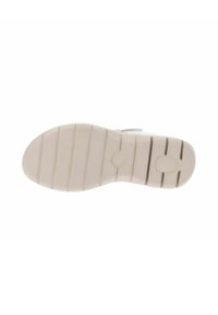 Suola di scarpa in gomma beige con un motivo testurizzato, caratterizzata da molteplici scanalature orizzontali e tappi arrotondati per la trazione.