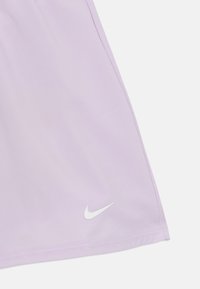Nike levendula színű sportnadrág, könnyű anyagból készült, fehér logóval és tiszta varrási részletekkel az alsó szegélyen.