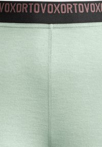 Light green leggings with a textured finish, featuring a black waistband with repeated pink logo text. Clean seams and fitted design.