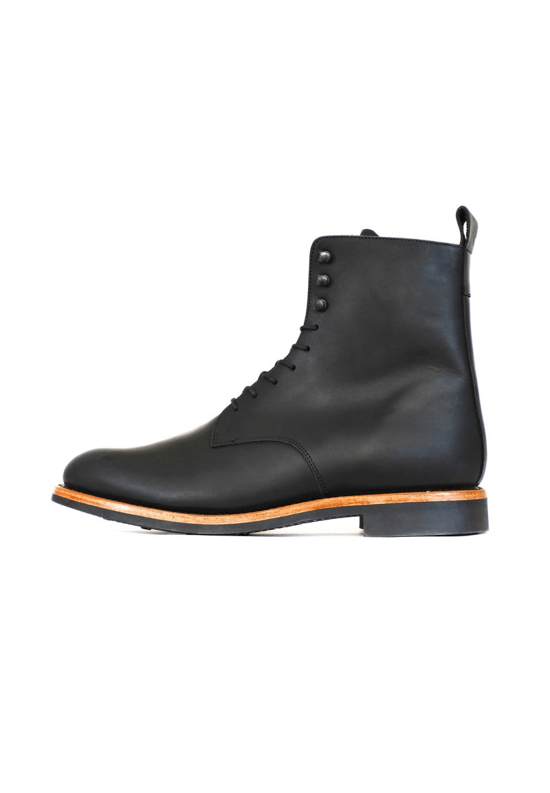 Stivale alla caviglia in pelle nera con finitura liscia, punta rotonda, chiusura con lacci e quattro occhielli in metallo. Presenta una suola intermedia in legno marrone chiaro e suola in gomma.