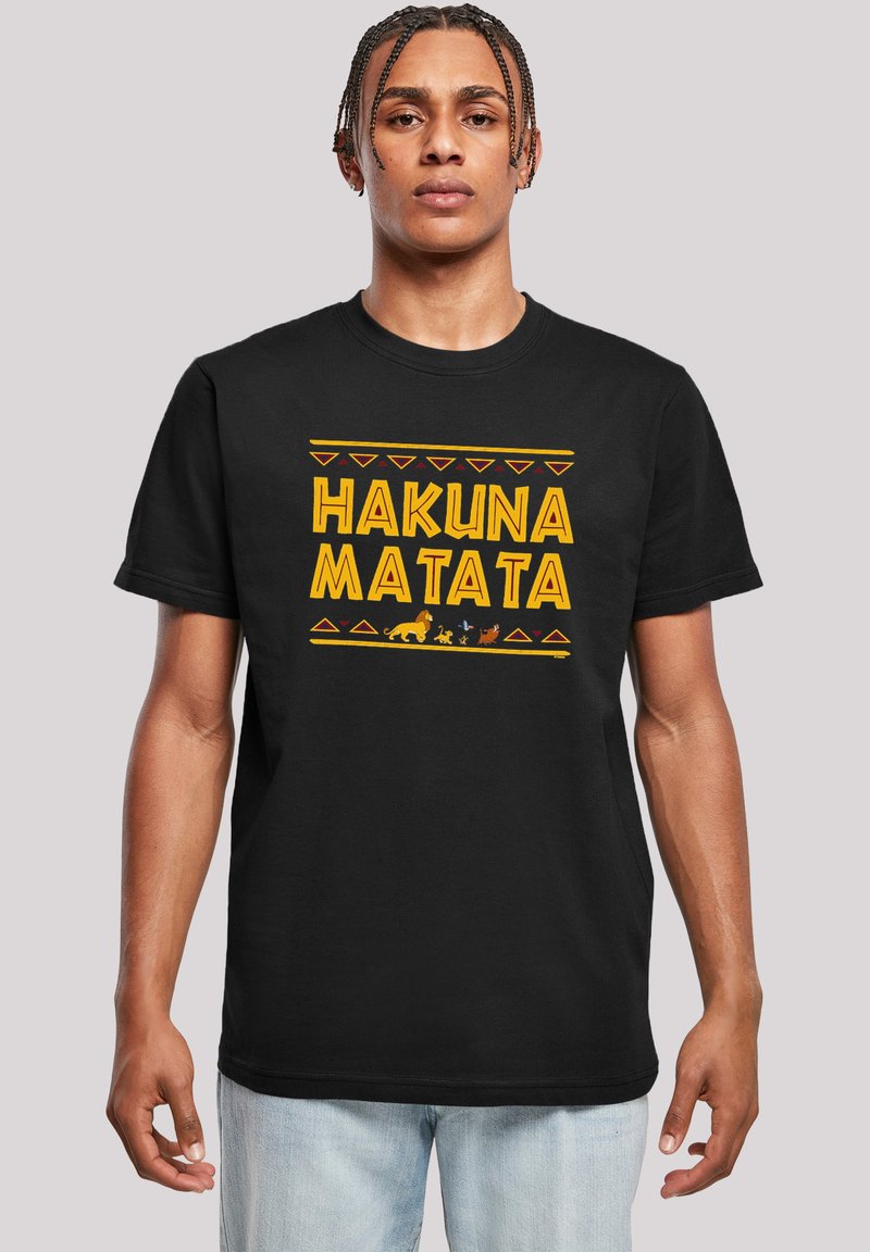 Melnas kokvilnas T-kreklus ar uzrakstu "HAKUNA MATATA" treknā dzeltenā krāsā, papildināts ar dzīvnieku silueti un ciltīs iedvesmotiem rakstiem sarkanā krāsā.