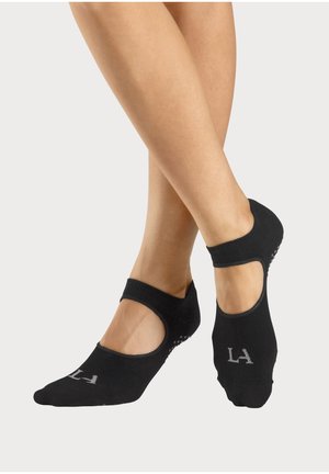 Schwarze Knöchelsocken mit Ausschnitten und rutschfester Grip auf der Sohle, mit einem "LA"-Logo und einem gerippten Elastikband. Weiches Baumwollmaterial.