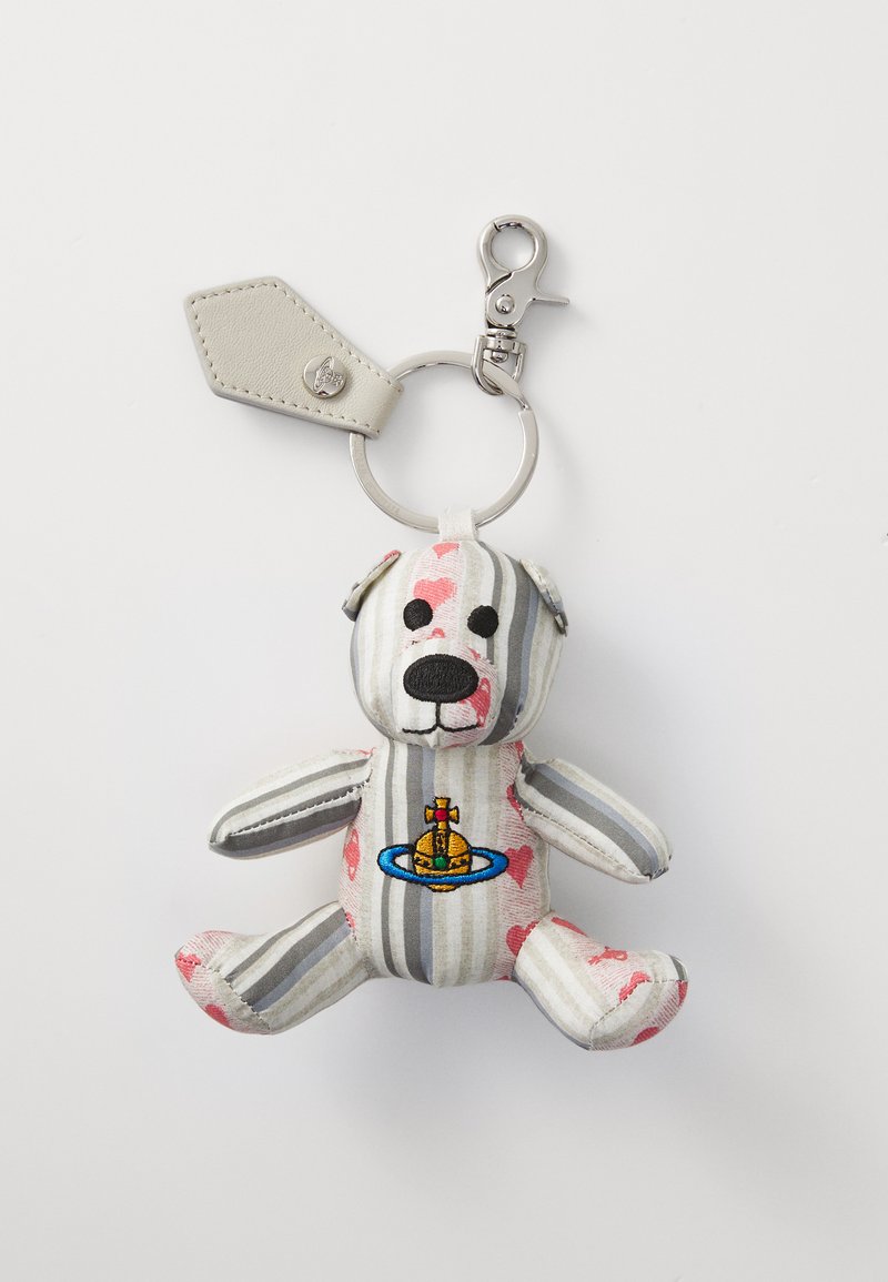 Striped fabric keychain bear with pink accents, embroidered details, and a metal clip. Features a circular emblem on its chest.