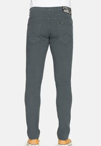 Pantaloni grigi attillati con una texture liscia, dotati di due tasche posteriori, cuciture a contrasto e un'etichetta visibile in vita.