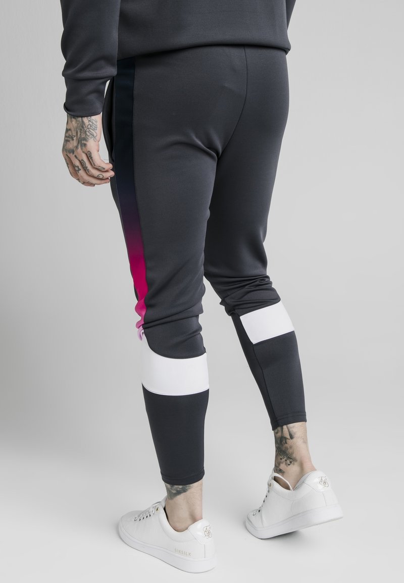Schwarze sportliche Jogginghosen mit seitlichen Farbverlauf-Paneelen in Pink und weißen Akzenten. Glatter Stoff und eng anliegendes Design mit elastischen Bündchen und Bund.