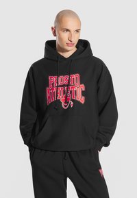 Czarna bluza z kapturem wykonana z bawełny z przednią kieszenią typu kangur. Posiada wyraźny napis "PROSTO ATHLETIC" w czerwonym kolorze oraz pasujący wzór na spodniach.