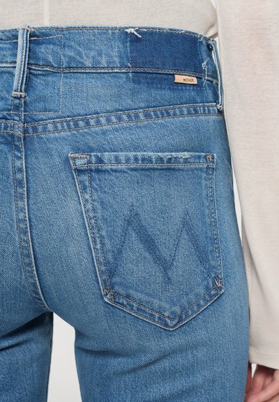 Lichtblauwe denim jeans met een rechte snit, voorzien van een kenmerkend 'M' stikselpatroon op de achterzak en een leren label bij de tailleband.