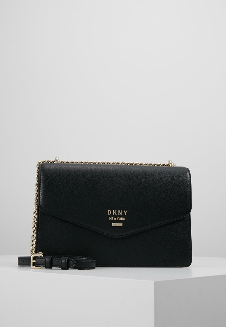 Svart läder axelremsväska med guldkedjearm, vikbar klaff och präglad logotyp på framsidan. Texturerad yta med minimala accenter.