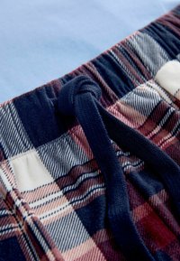 Korte bukser med tern i marineblå, bordeaux og cremefarver med en blød frottétekstur. Inkluderer en marineblå snor på en elastisk linning.