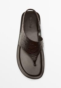 Sandalo infradito in pelle marrone scuro con cinturino texturizzato e anello sul tallone, suola piatta e nome del marchio in rilievo sulla soletta.