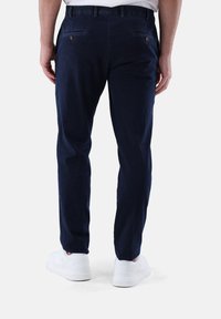 Marineblaue Hose mit geradem Bein Design, aus leichtem Stoff gefertigt. Verfügt über Gesäßtaschen mit Knöpfen und einer glatten Textur.