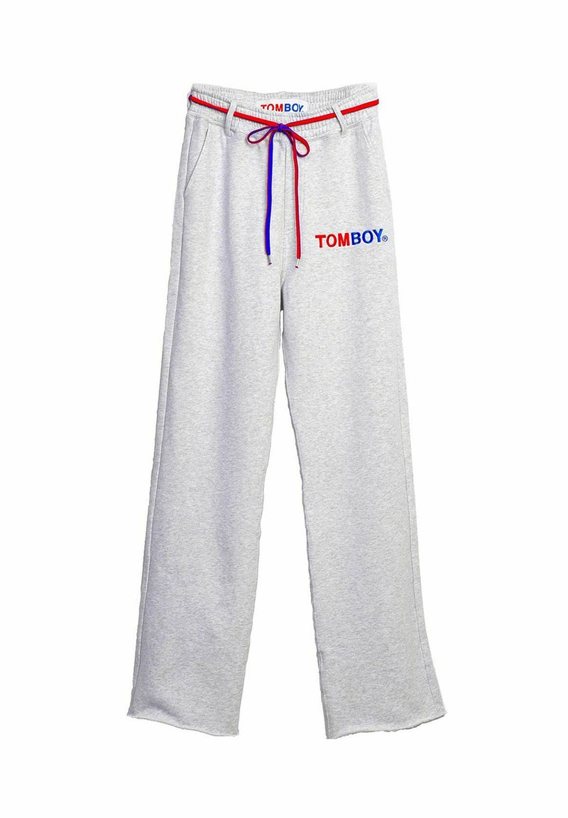 Grijze trainingsbroek met een ontspannen pasvorm, featuring een trekkoord in de taille met rode en blauwe accenten en "TOMBOY" in rood en blauw gedrukt.