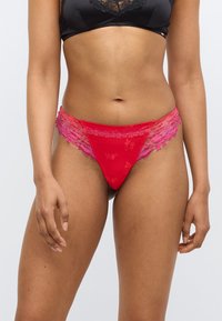 Κόκκινο δαντελένιο στρινγκ με λουλουδάτα σχέδια,  με διαφανή ροζ δαντελένια επένδυση στα πλάγια, σχεδιασμένο με απαλό ύφασμα για άνεση.