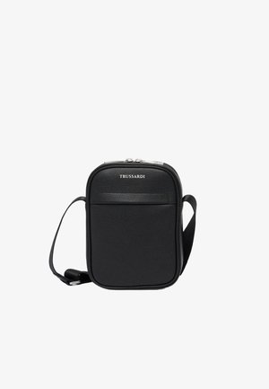 Bolso de cuero negro tipo bandolera con forma rectangular, cuenta con un bolsillo frontal, herrajes en plata y una correa ajustable. Logotipo grabado en la parte superior.