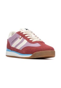 Zapatillas de ante rojas y lavanda con rayas blancas, punta redondeada y cordones crema. Cuenta con una entresuela azul y una suela de goma texturizada color goma.