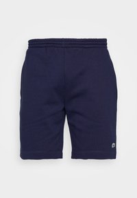 Shorts bleu marine à taille élastique avec un petit logo crocodile vert et blanc près de l'ourlet inférieur sur la jambe gauche.