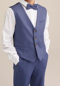 Blå texturerad väst med en vit skjorta och matchande fluga. Vesten har en slim fit, fem knappar och två framfickor.