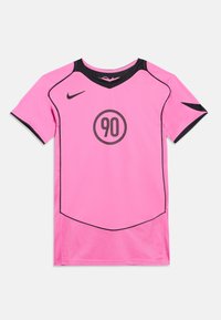 Φωτεινή ροζ αθλητική φανέλα με μαύρο περίγραμμα, λογότυπο Nike στο δεξί στήθος και έναν μαύρο κύκλο με το "90" στο κέντρο μπροστά.