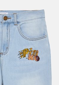 Jeans de mezclilla azul claro con un diseño ajustado que presenta un logotipo de "PINKO" colorido de lentejuelas en amarillo, naranja y rojo.