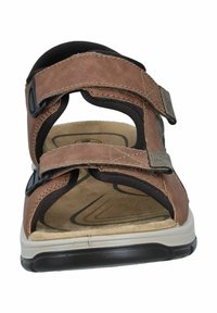Brown leather sandals with adjustable black fabric straps, open toe and heel design, cushioned footbed, and a white rubber sole.