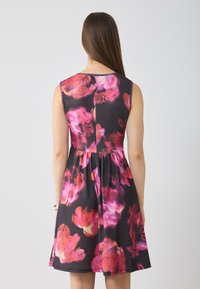 Robe florale noire avec des motifs roses et violets, design sans manches, corsage ajusté et jupe évasée, en tissu lisse.