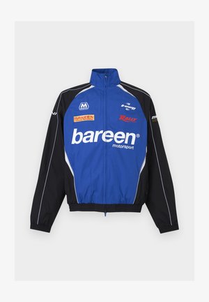 Sinine ja must vormelispordi jope ees tõmblukk ja "bareen" logo, millel ees ja varrukatel mitu sponsorilogot.