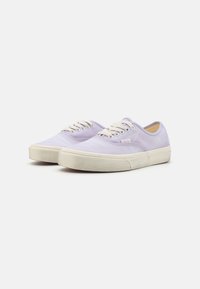 Baskets en toile violettes avec des lacets blancs et des semelles en caoutchouc, présentant un design basse et des détails de couture classiques.