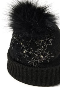 Gorro de punto negro con un grueso puño acanalado, que cuenta con bordado floral y lentejuelas. Rematado con un gran pompón de pelo negro para aportar textura.